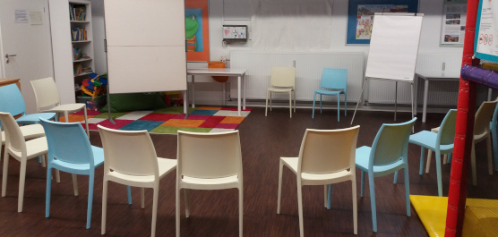 Foto eines Seminarraumes mit Flipchart und Stuhlkreis