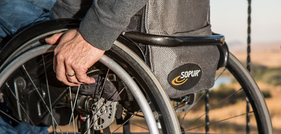 Bildausschnitt einer Person, die im Rollstuhl sitzt
