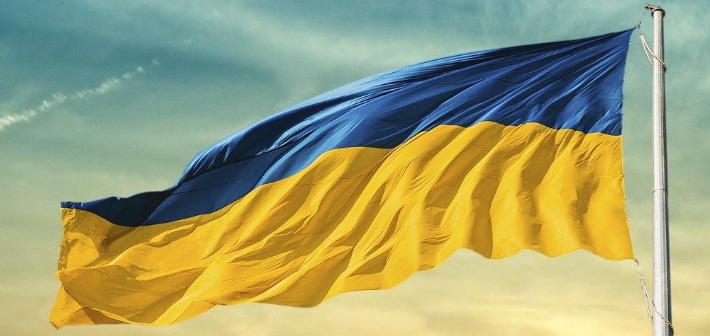 Foto: Im Wind wehende Flagge der Ukraine, dahinter Himmel