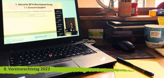 Ein Laptop auf einem Schreibtisch; auf dem Bildschirm des Laptops läuft die Konferenz "Vereinsrechtstag 2023", man sieht einen Redner (klein) sowie (groß) die Folie, über die er gerade spricht: "Aktuelle BFH Rechtssprechung - Gemeinnützigkeit" (mehr ist nicht erkennbar).