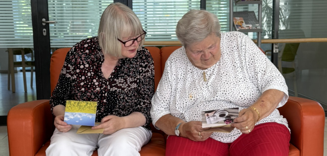 Zwei Damen lesen ihren Postkartengruß